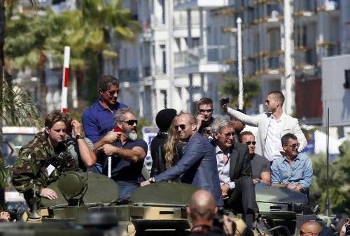 Cast members Sylvester Stallone, Mel Gibson, Jason Statham, Harrison Ford, Arnold Schwarzenegger and Antonio Banderas  pose on a tank as they arrive on the Croisette to promote the film "The Expendables 3" during the 67th Cannes Film Festival in Cann