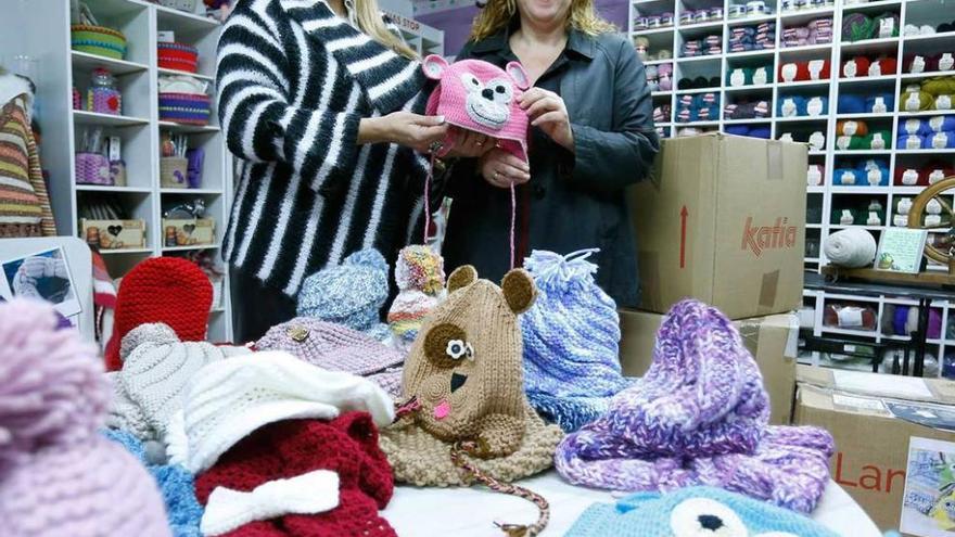 Pilar Menéndez, a la izquierda, entrega los gorros y bufandas.