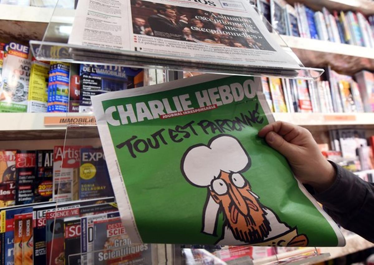 Un home mira el seu exemplar de ’Charlie Hebdo’, davant d’un quiosc de Montpeller.