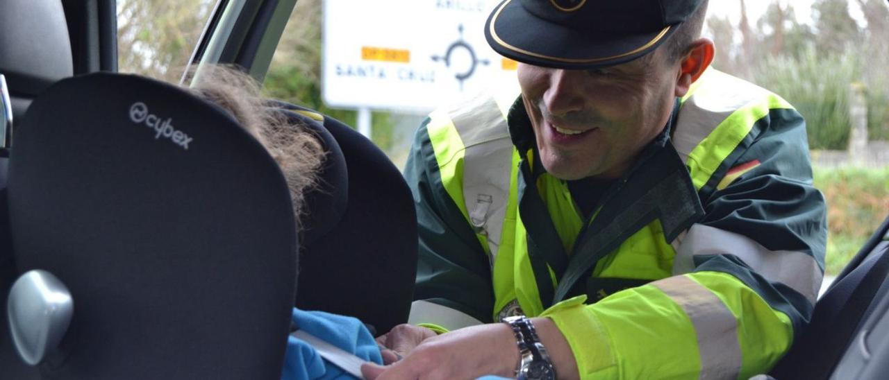 Un agente de la Guardia Civil de Tráfico, durante el control a un silla de retención infantil. |   // HÉCTOR T.