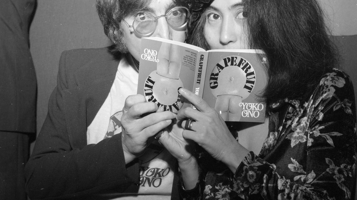 John Lennon y Yoko Ono leen un libro.