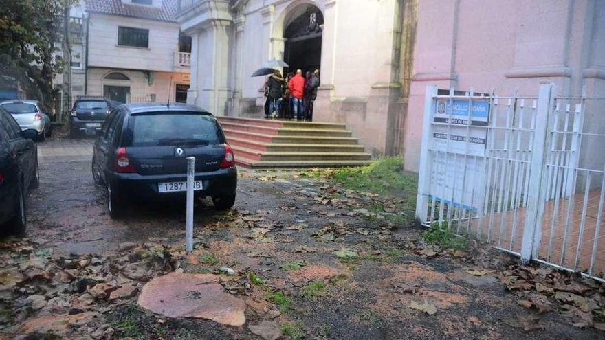 Los vecinos en la puerta de la iglesia y, en primer término, el tocón de uno de los árboles talados./ G.N.