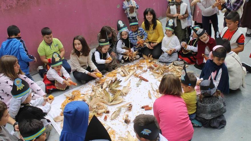 Los niños desgranando maíz, ayer, en el colegio público Padre Galo de Luarca.