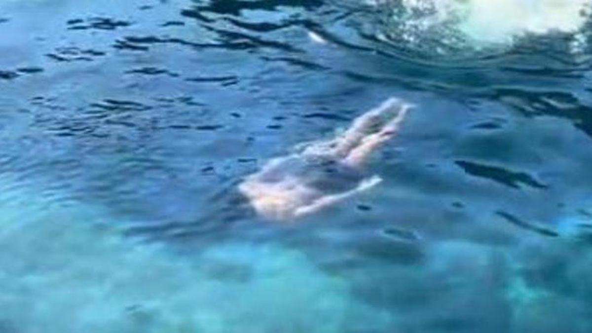 Una pareja se baña en una cala en invierno