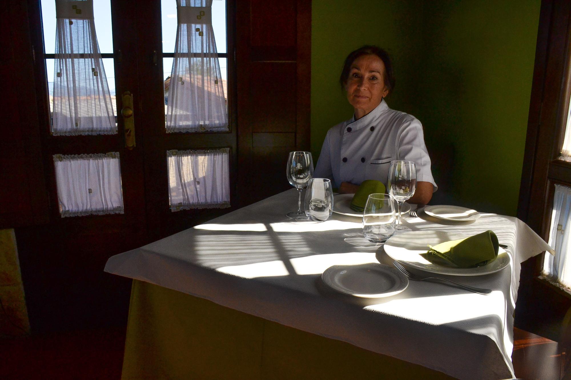 Marisol Remis, sentada a una de las mesas en el comedor de su restaurante, Atalaya, en Torín (Piloña)