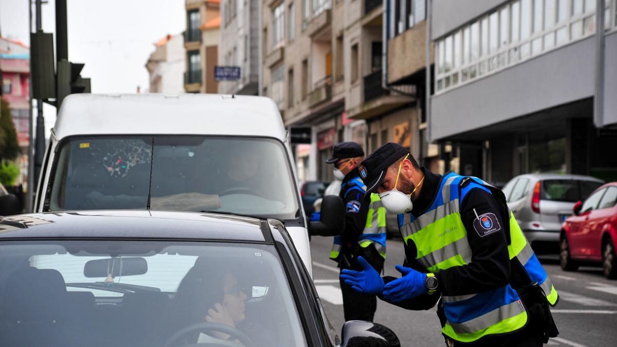Dos policías de Vilagarcía dan indicaciones a sus vecinos.