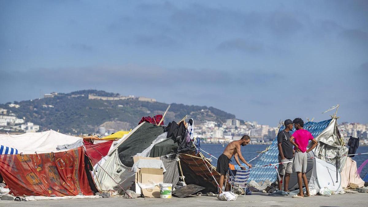 Varios migrantes asentados en la playa del Trampolín, a 31 de agosto de 2026, en Ceuta (España). La playa del Trampolín, vuelve a concentrar un gran número de chabolas improvisadas pese al traslado previo de personas migrantes a otros espacios habilitados