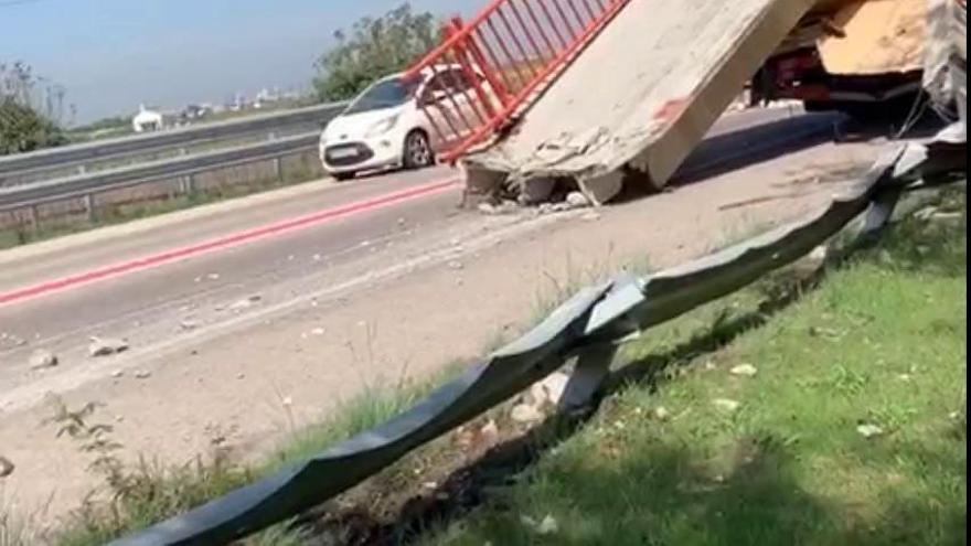 Un camión grúa se lleva por delante una pasarela peatonal de hormigón en Valencia