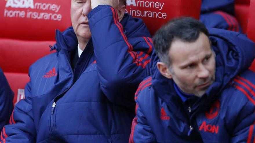 Van Gaal, sentado junto a Giggs, hace un gesto de desesperación durante el partido. // Reuters