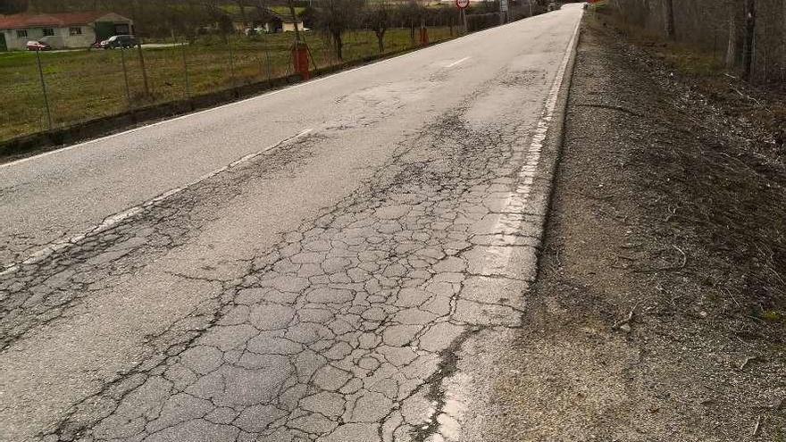 Firme en mal estado con rodera profunda, grietas, deterioro de borde y desgaste de marcas viales.