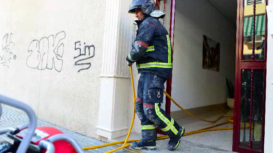 Un bombero sofoca un incendio en una vivienda de Cartagena.