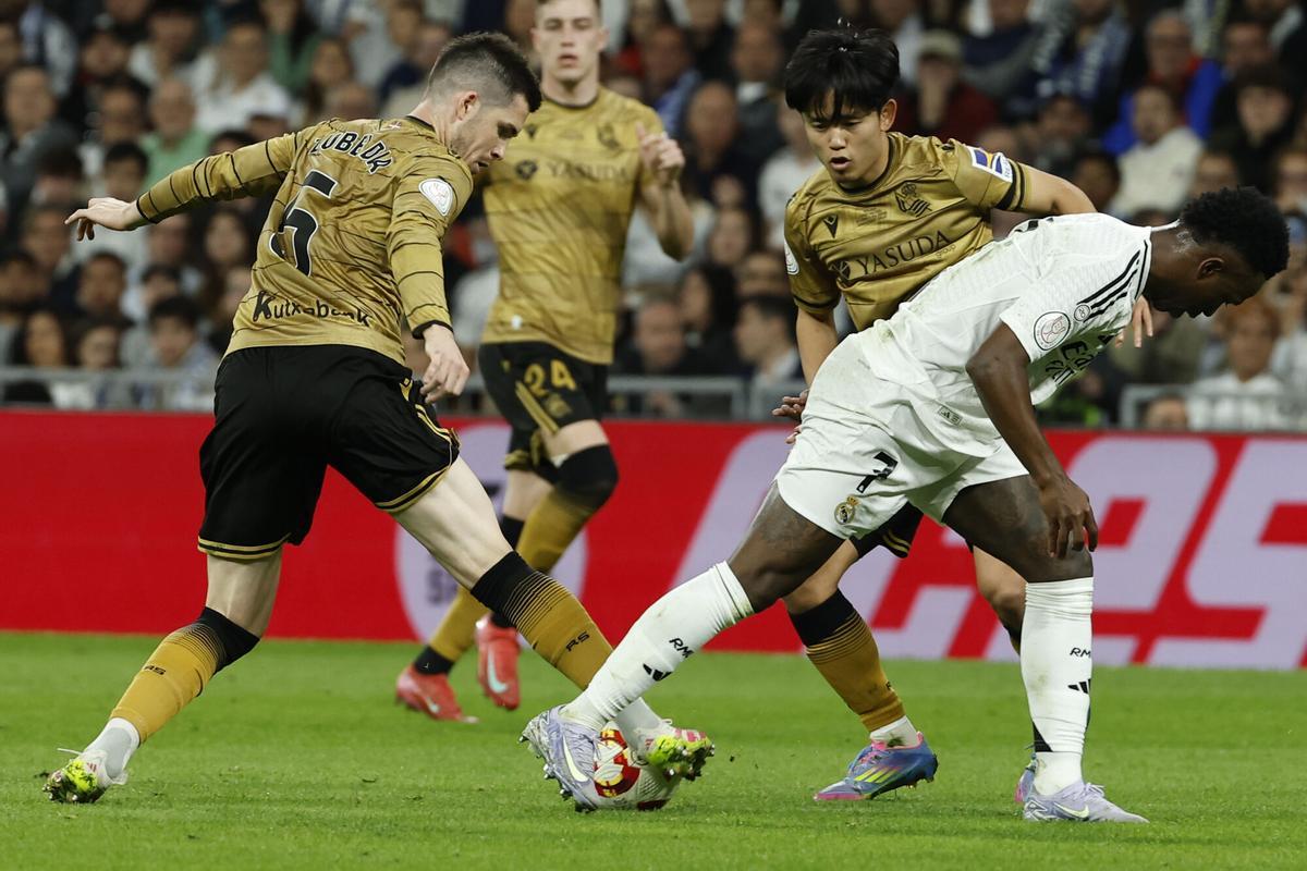 MADRID, 01/04/2025.- El delantero brasileño del Real Madrid Vinícius Júnior (d) disputa un balón ante los jugadores de la Real Sociedad Igor Zubeldia (i) y Take Kubo, durante el partido de vuelta de las semifinales de la Copa del Rey que Real Madrid y Real Sociedad disputan hoy martes en el estadio Santiago Bernabéu. EFE/Chema Moya