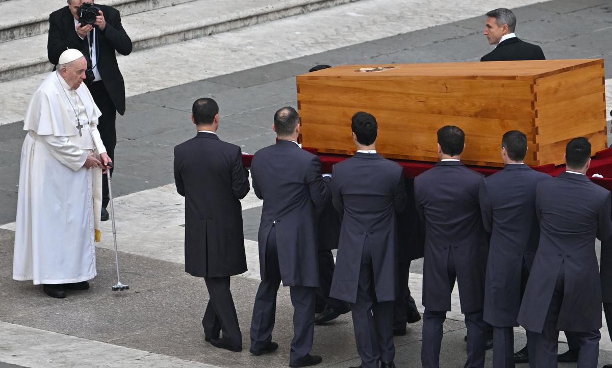 Los portadores del féretro llevan el ataúd del Papa Emérito Benedicto XVI frente al Papa Francisco al final de su misa fúnebre en la plaza de San Pedro en el Vaticano.