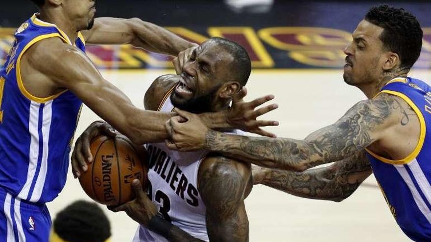 Lebron entre dos jugadores de los Warriors.