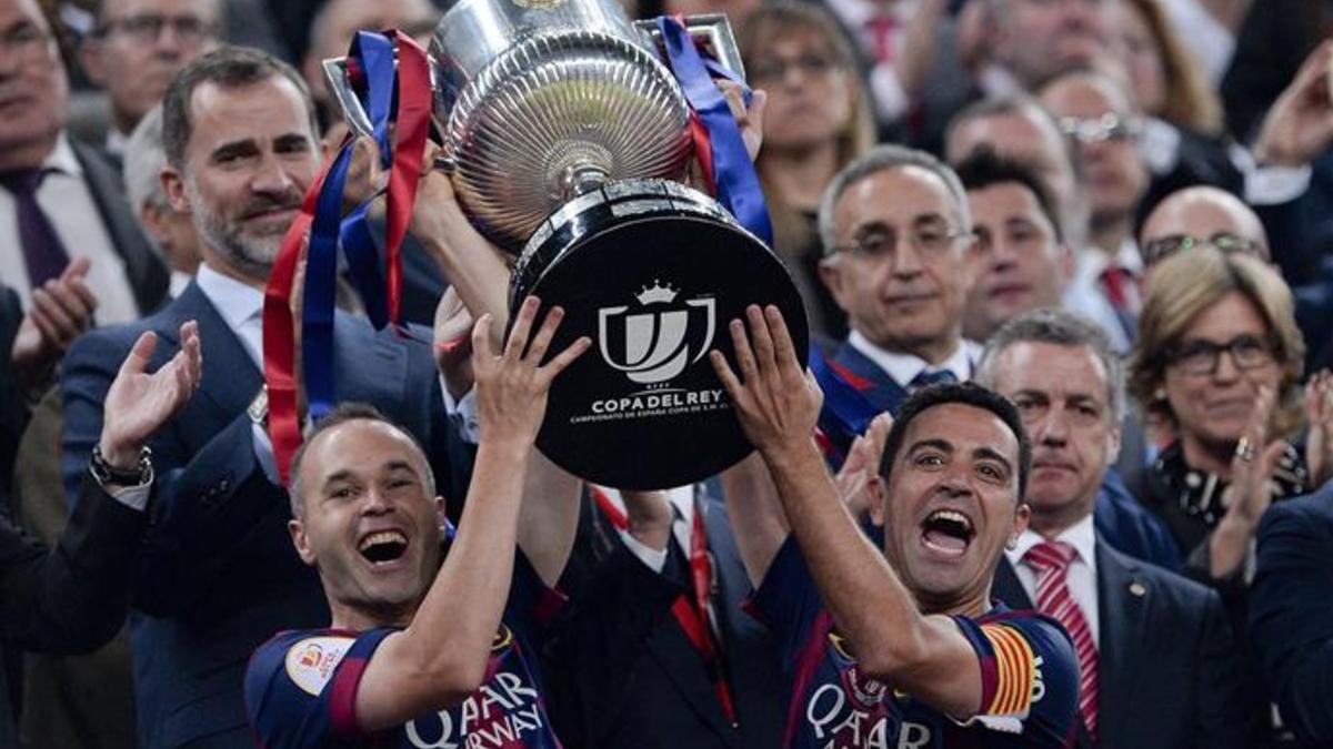 Iniesta y Xavi, con el trofeo de la pasada temporada