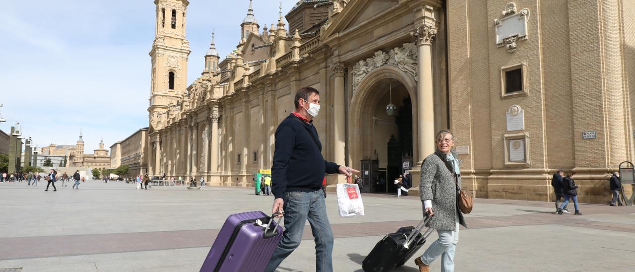 Dos turistas este mediodía en la plaza del Pilar, en Zaragoza.