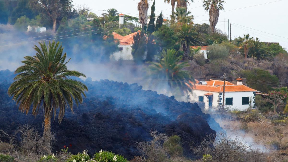 The lava flows next to houses following the eruption of a volcano in Spain