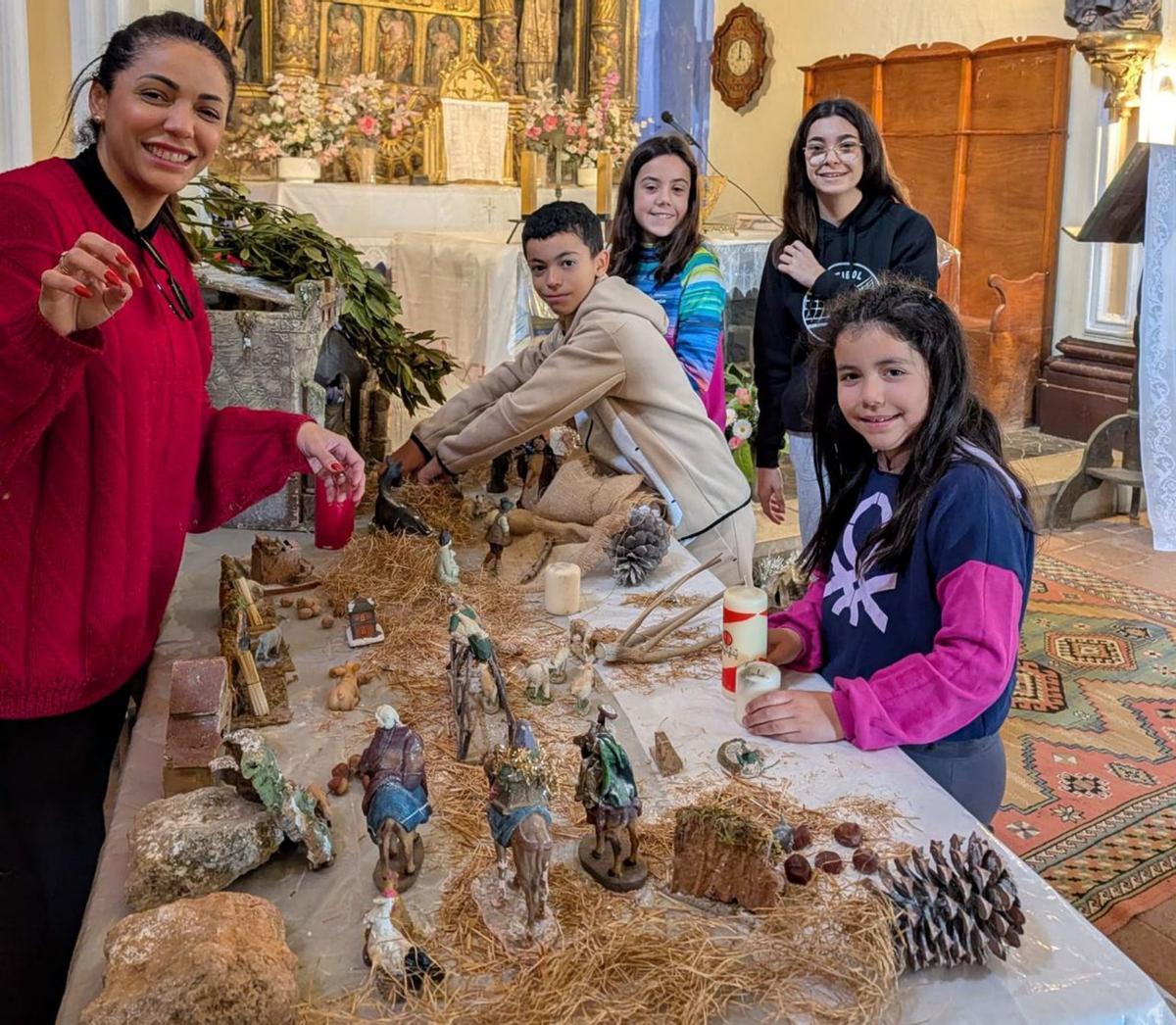 Los más jóvenes de Aladrén preparan el Belén en la iglesia.