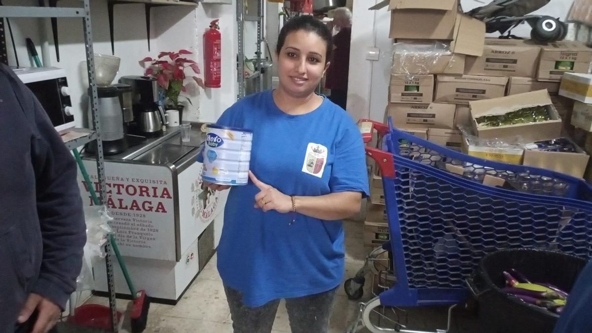 Una voluntaria de la Asociación de Vecinos de Lagunillas, con un tarro de alimento infantil.