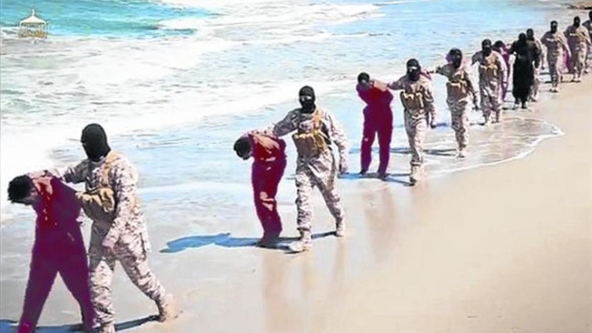 Imagen del vídeo del EI con yihadistas encapuchados conduciendo a sus víctimas por una playa de Libia.