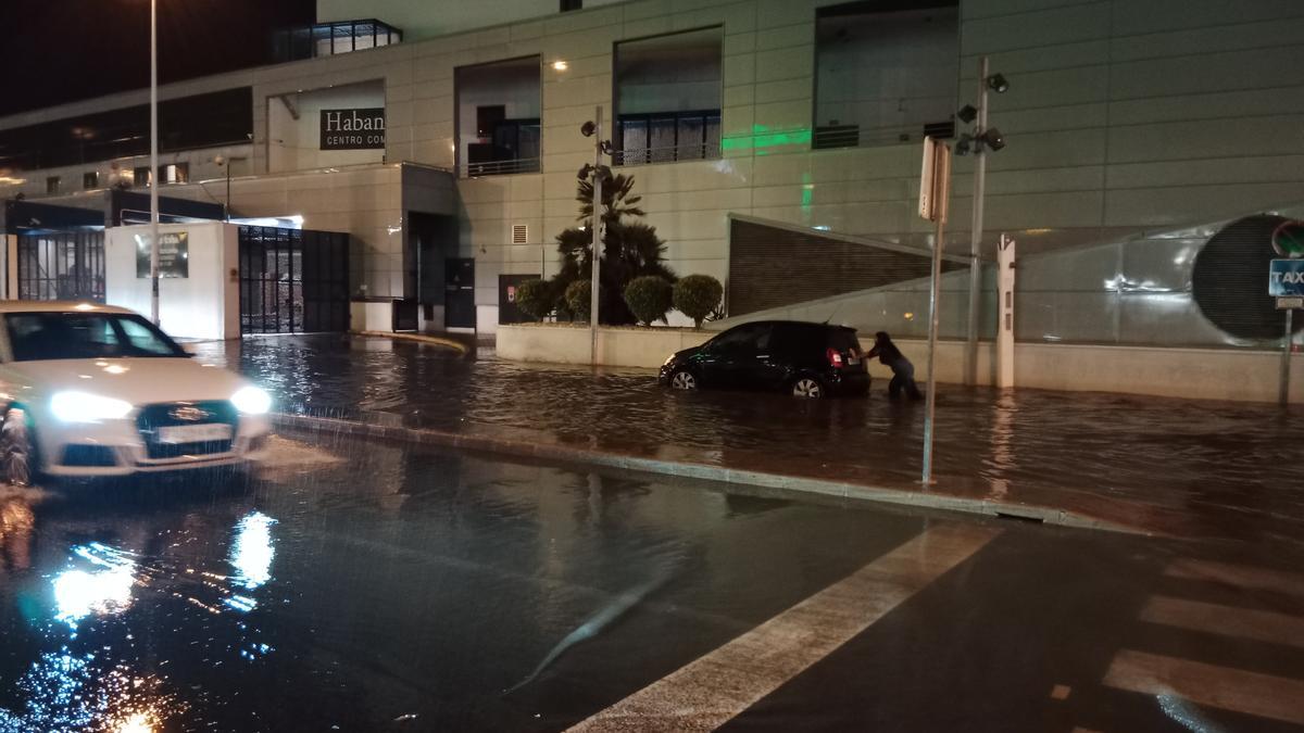 Uno de los vehículos atrapados por la acumulación de agua en la avenida de Rosa Mazón a la altura de Ozone y el CC Habaneras