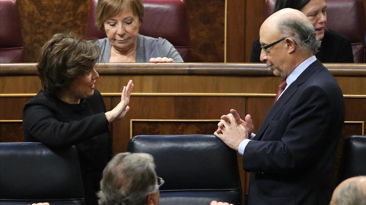 La vicepresidenta Soraya Sáenz de Santamaría y el ministro de Hacienda, Cristóbal Montoro, en un Pleno del Congreso