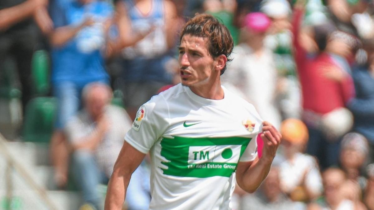 Pere Milla se señala el escudo, durante un partido en su etapa con el Elche