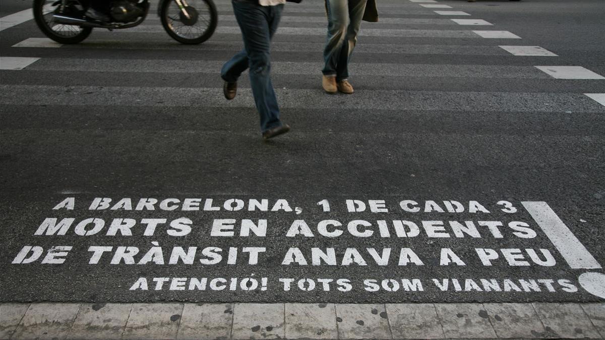 Aviso para peatones sobre la calzada en una calle de Barcelona.