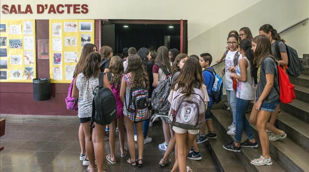 Alumnos cargados con mochilas escolares en el instituto Moisès Broggi de Barcelona.