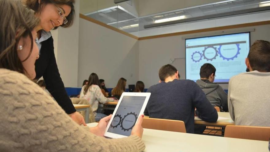 Una profesora muestra a una alumna cómo funcionan los dispositivos durante una clase.