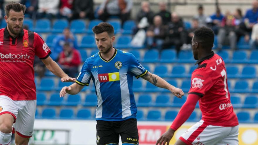 El alicantino Miñano, entre dos jugadores del Mallorca