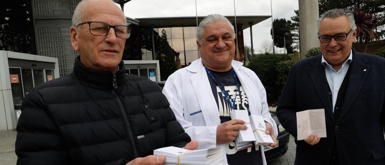 Julián Menéndez y Juan García entregan a Ricardo de Dios, gerente del Hospital Universitario San Agustín de Avilés, los dípticos poéticos a repartir el día 21.