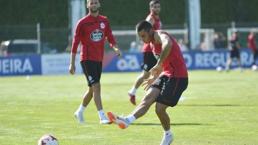 David Simón golpea la pelota ayer en Abegondo en presencia de Domingos Duarte y Eneko Bóveda.