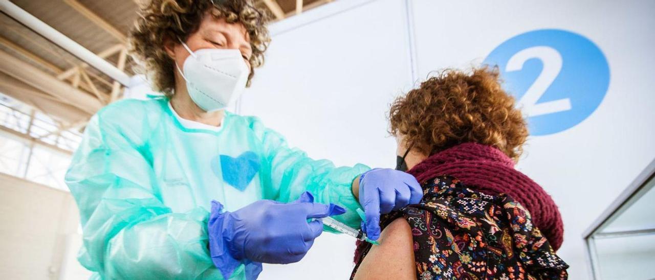 Una sanitaria vacuna a una mujer, en una imagen de archivo, en el Recinto Ferial. | VICENT MARÍS