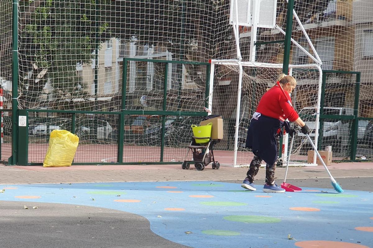 Un carrito de bebé recoge la basura retirada por una trabajadora.