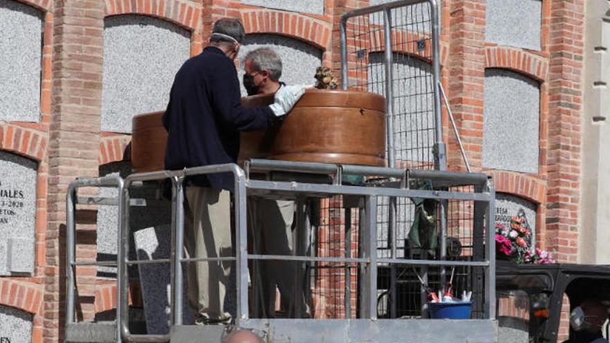 Unos operarios entierran a una víctima del Covid-19 en Madrid.