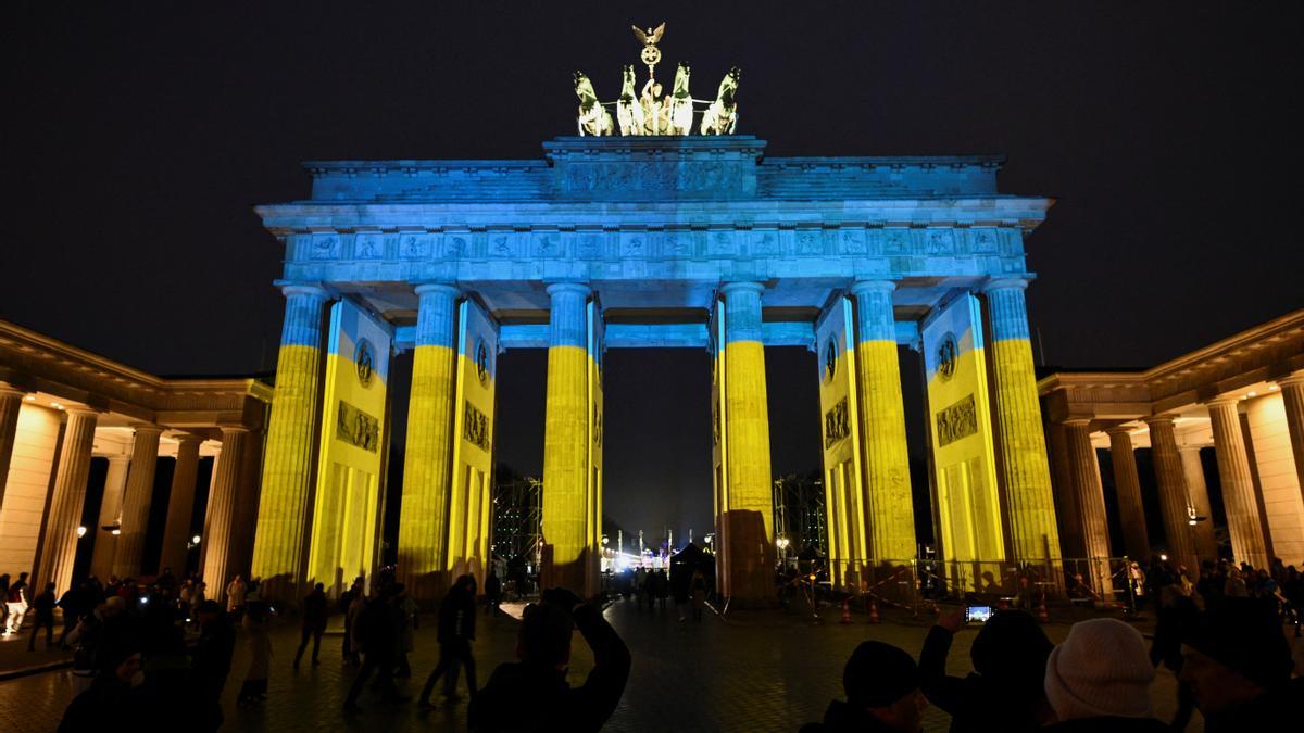 Una imagen de la concentración en Berlín con la Puerta de Brandenburgo iluminada con los colores de la bandera de Ucrania.