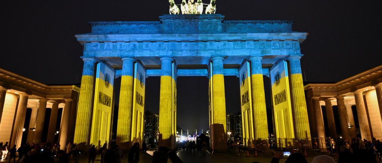 Una imagen de la concentración en Berlín con la Puerta de Brandenburgo iluminada con los colores de la bandera de Ucrania.