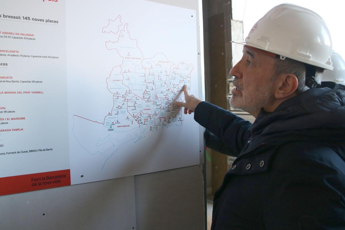L'alcalde de Barcelona, Jaume Collboni, assenyala un mapa de la ciutat amb les escoles bressol municipals
