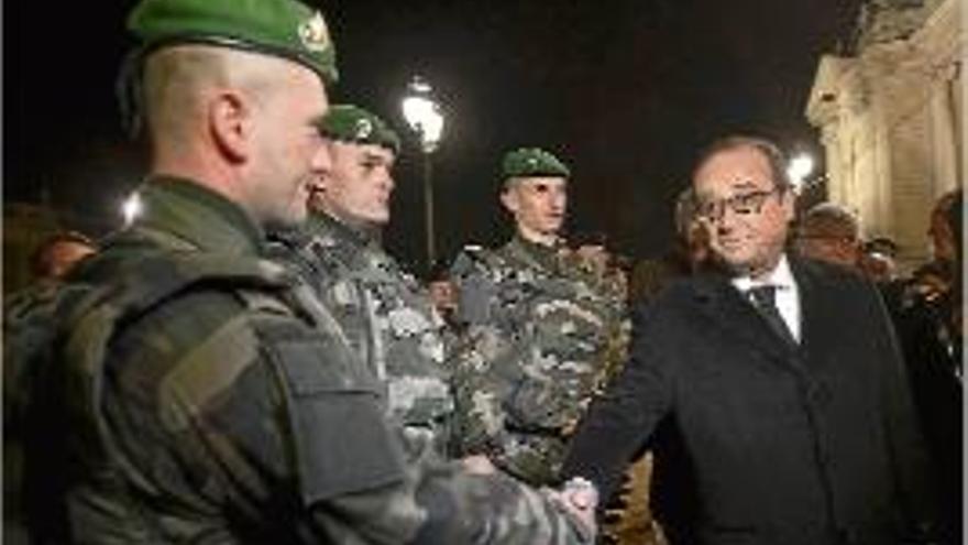 Hollande saluda un grup de soldats a París.