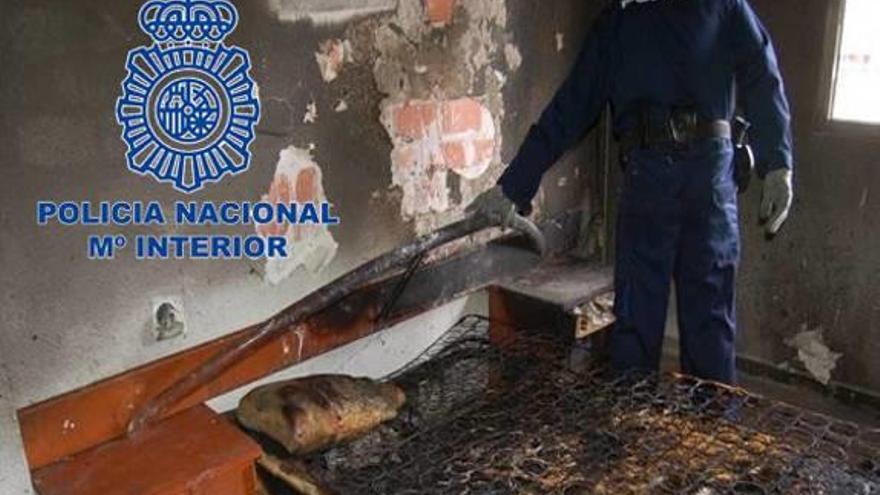 Un policía en la inspección de la casa incendiada.