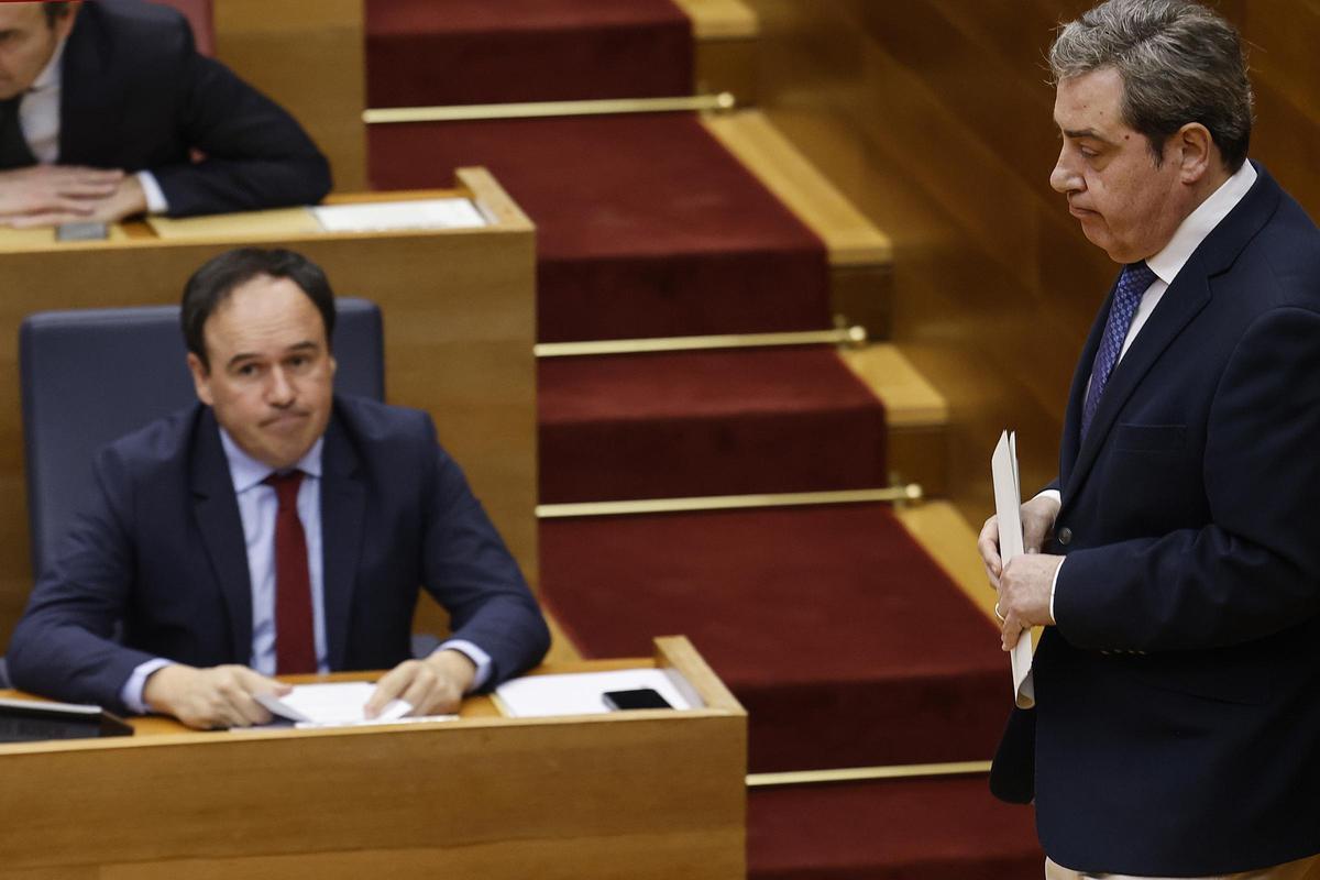 José María Llanos (Vox) pasa ante el escaño de Pérez Llorca.