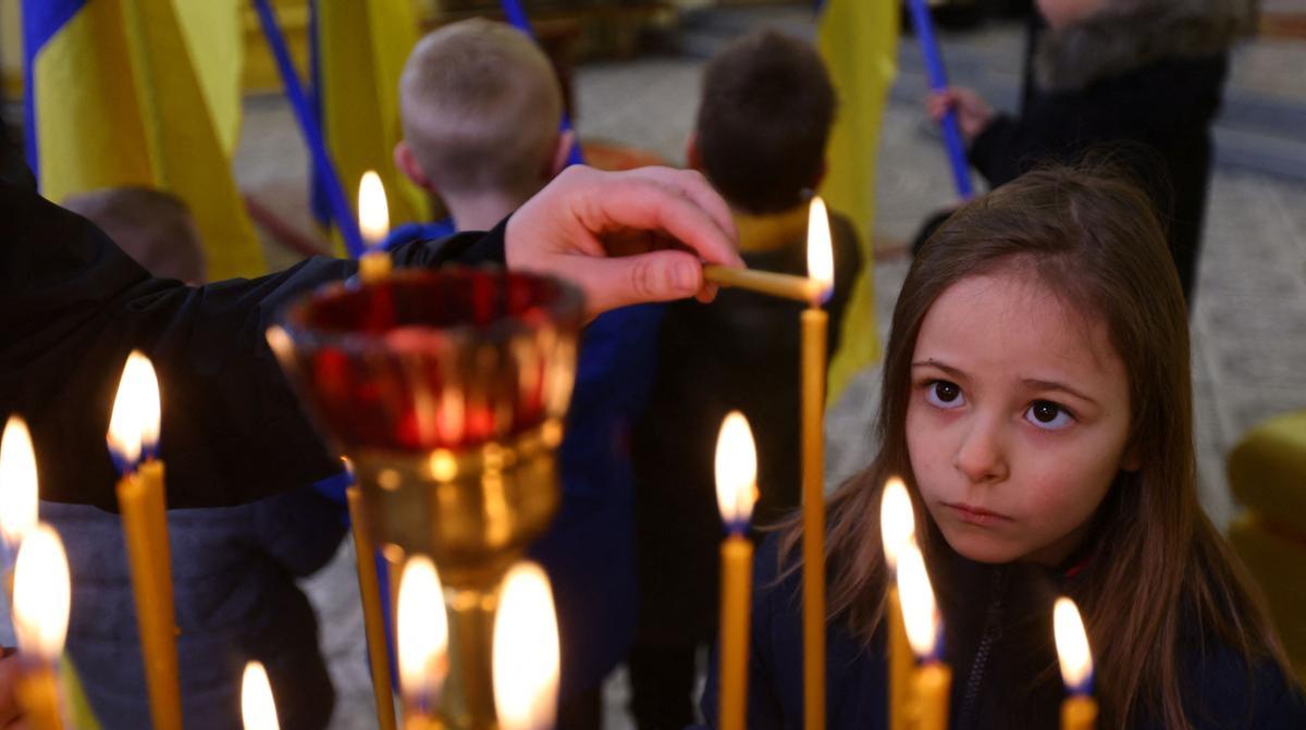 Un niña observa cómo se enciende una vela en la catedral baptista de St John en Przemysl, lugar en la frontera polaca con Ucrania que acoge a miles de evacuados