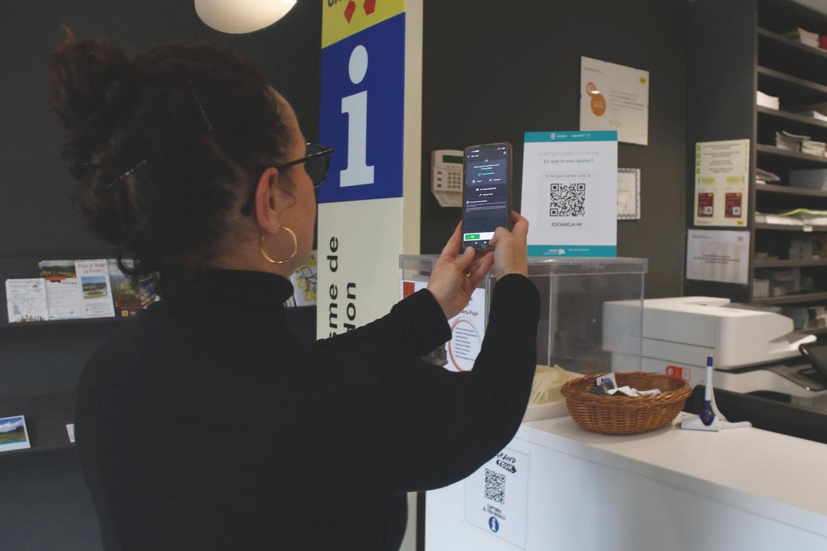 Una usuària escaneja el codi QR per activar la guia