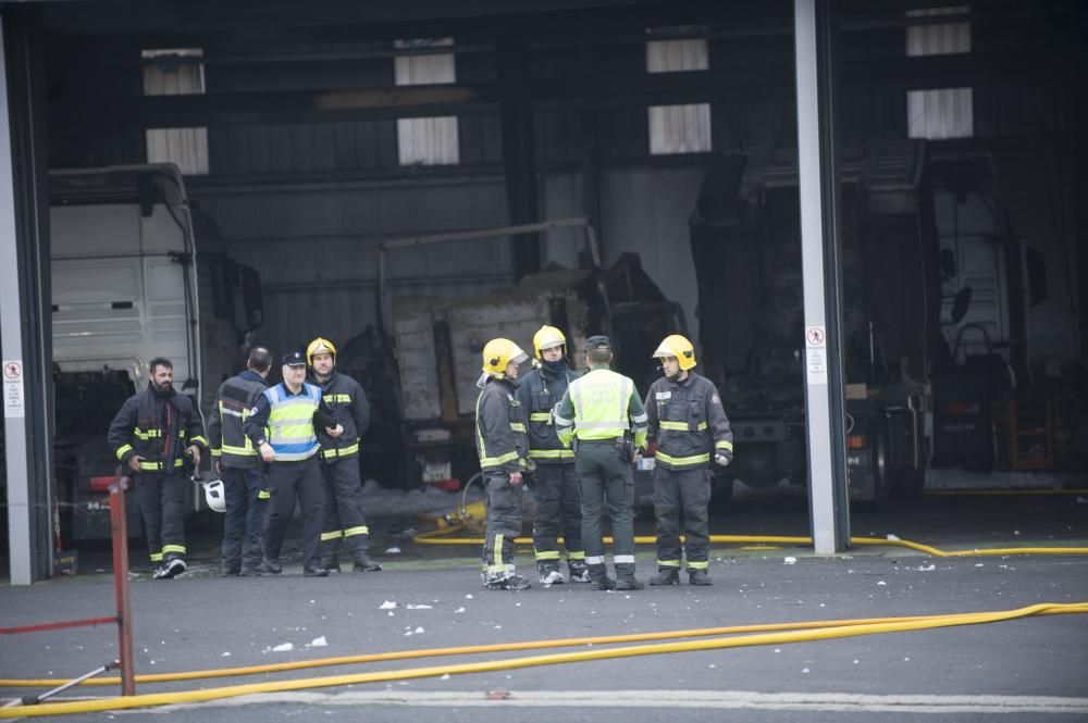 Bomberos del parque comarcal y efectivos de emergencias de Oleiros apagan un fuego en una nave de la compañía MAN situada junto a la Nacional VI - El fuego calcinó un camión y afectó a otros dos.