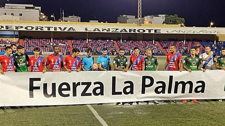 UD Lanzarote y Atlético Paso, club afectado por el volcán, posan con una pancarta en apoyo a La Palma. | | LANZAROTE DEPORTIVA