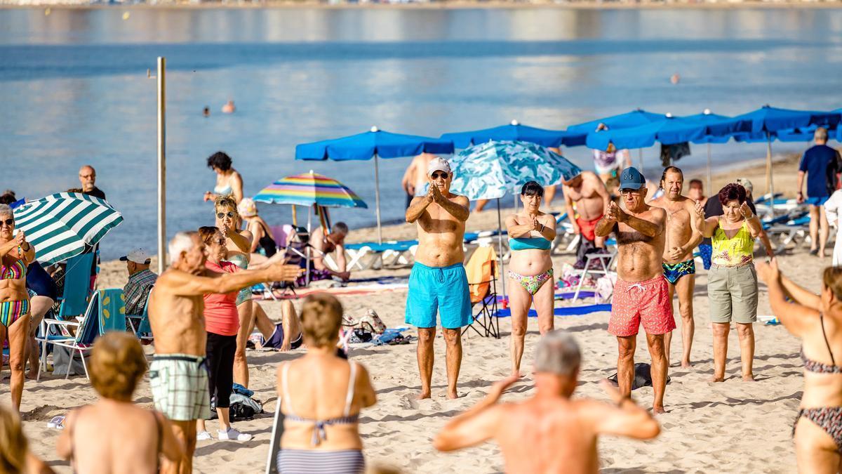 Turistas del Imserso haciendo gimnasia en la playa de Levante de Benidorm la pasada primavera.
