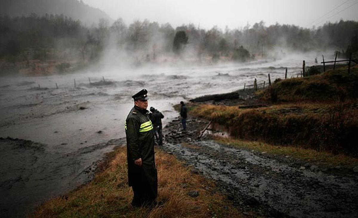 Un policia xilè observa aquest dijous les rodalies del riu Nilahue, que s’ha desbordat després de l’erupció dissabte passat del volcà Puyehue.