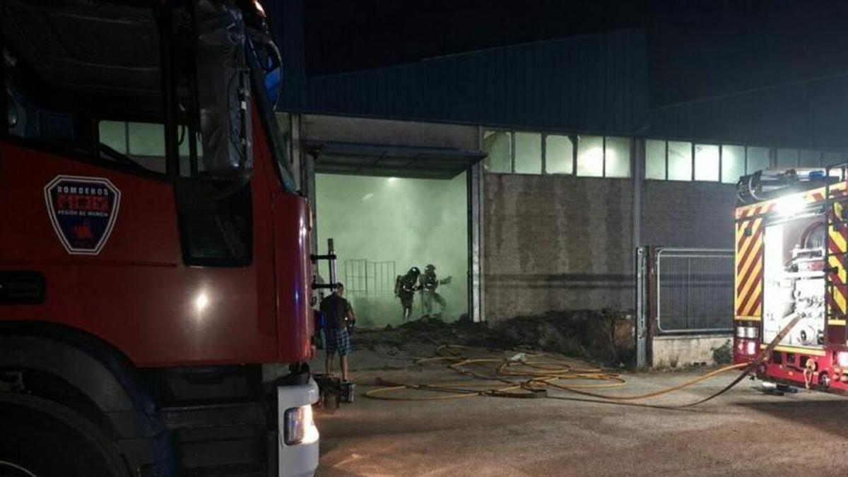 Bomberos trabajan en el lugar del incendio de una empresa de tapizados en Yecla.
