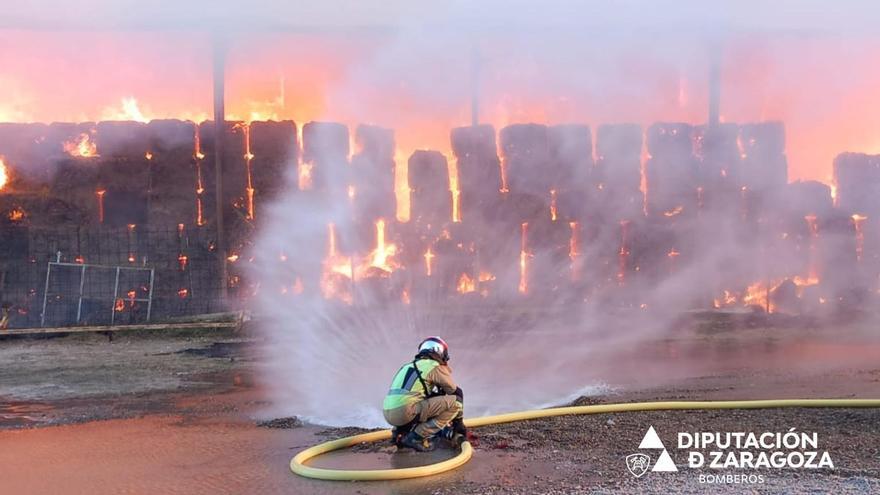 Los bomberos de la DPZ trabajan en la extinción del incendio de una nave en Torres de Berrellén
